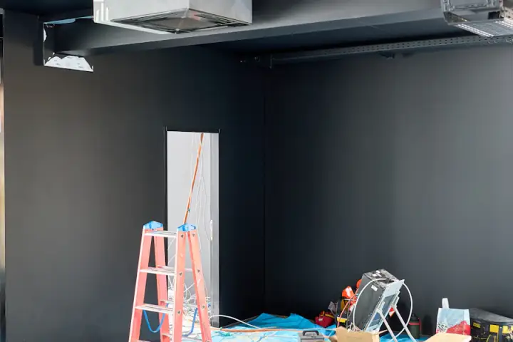 Unutrašnji prostor u renoviranju s merdevinama, alatima i zaštitnom folijom